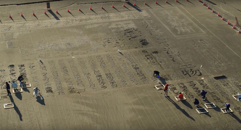 沙灘巨型報紙頭條！《東京新聞》沙雕藝術頭版呼籲正視海洋保育與污染